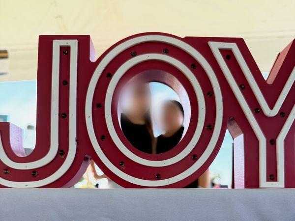 Large lighted JOY marquee letters at the Joy Mental Health Group booth at the Out of the Darkness Walk on Belle Isle