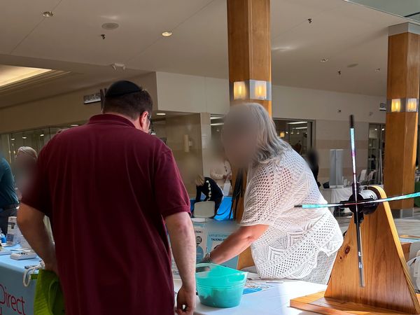 People stopping by the Joy Mental Health Group outreach table at the West Bloomfield Chamber Health & Wellness Fair at Orchard Mall